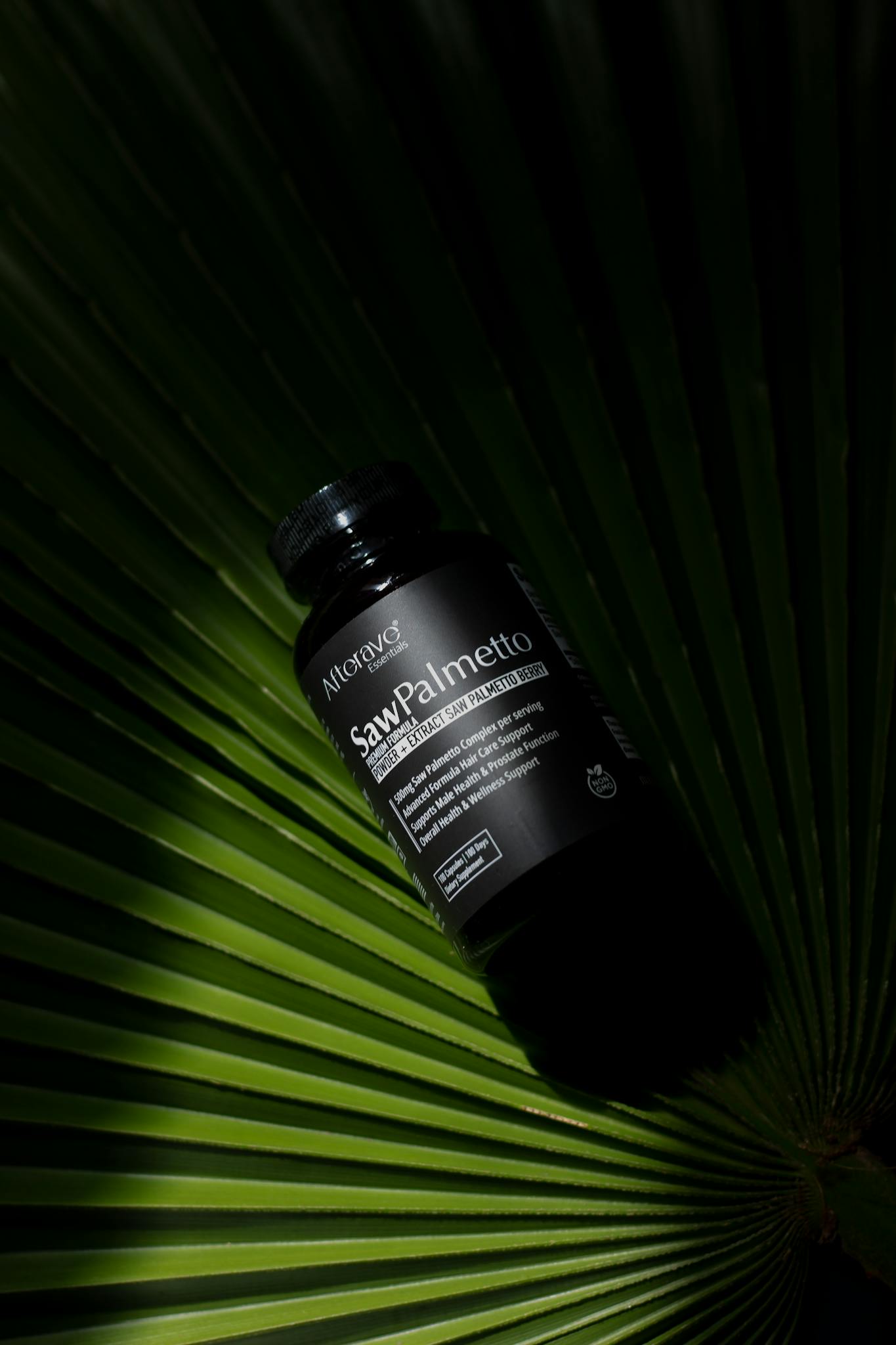 Saw Palmetto supplement bottle placed on a green palm leaf, capturing a natural essence.